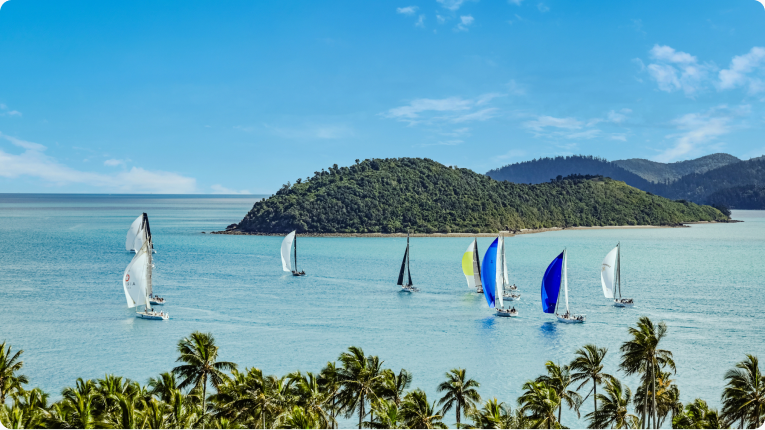 Yachts racing off the Whitsundays with Hamilton Island in the background