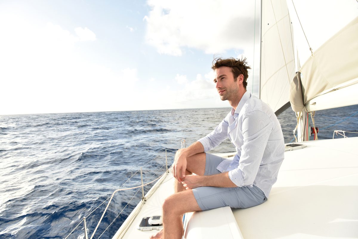 A man relaxing on the bow of a runabout on the water